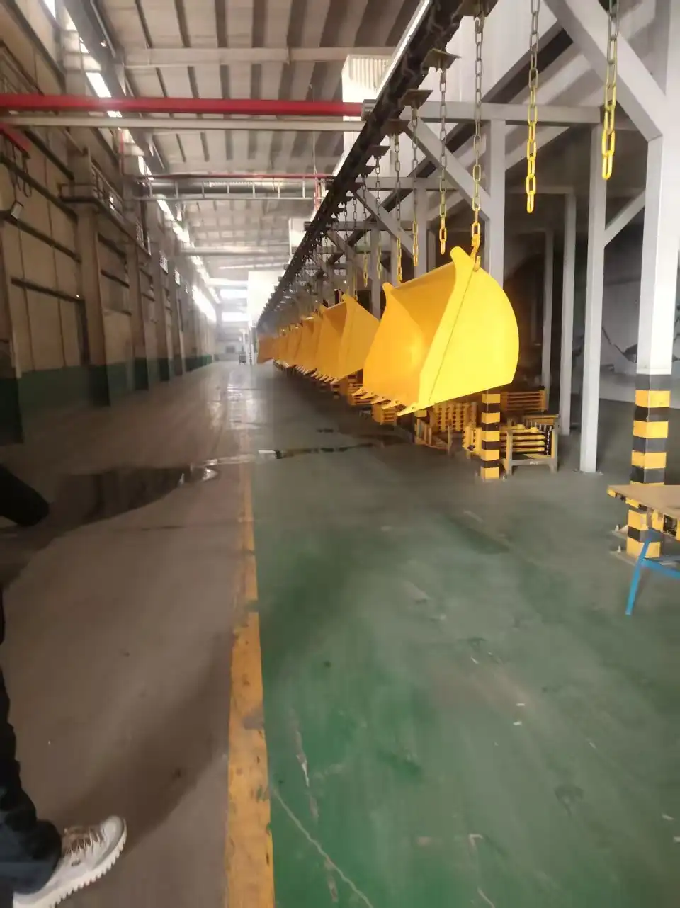 Yellow loader buckets leaving coating line